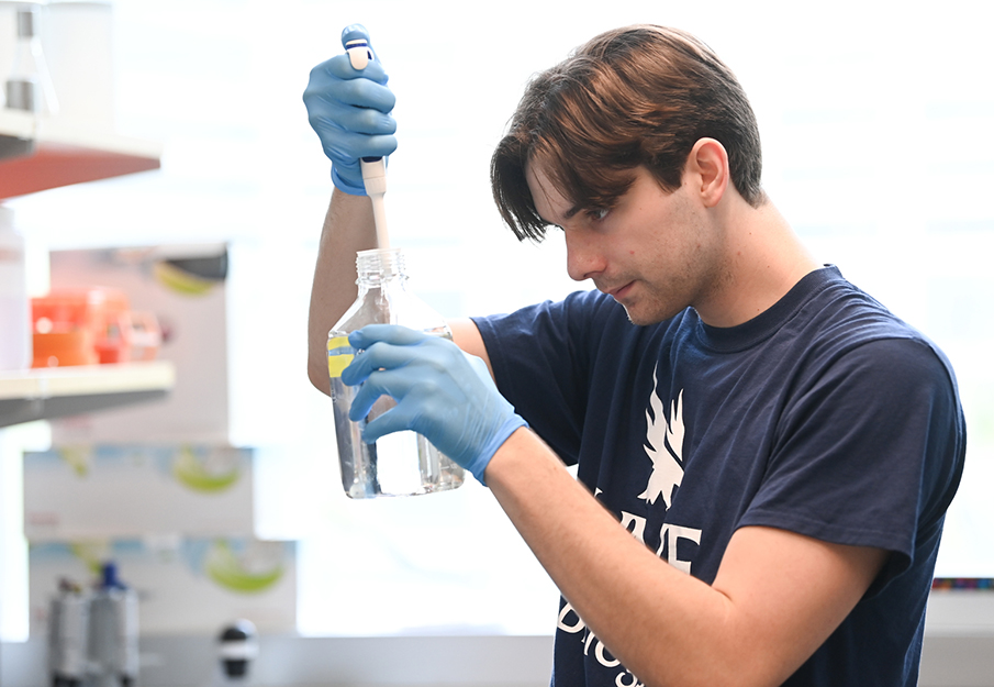 UNF biology student Alexander Bartkowiak working with lab instruments