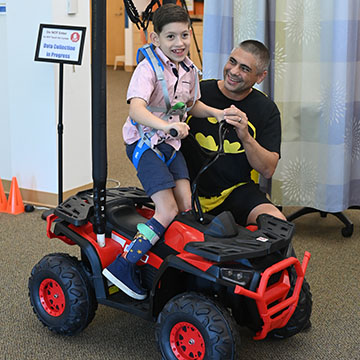 Dr. Guilherme Cesar and Finn Valentin showing off Finn's adaptive toy