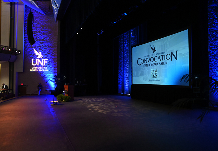 Projection screen on stage at UNF Convocation State of Osprey Nation event