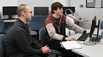 Furio Gerwitz and Jake Sutton working together on a computer
