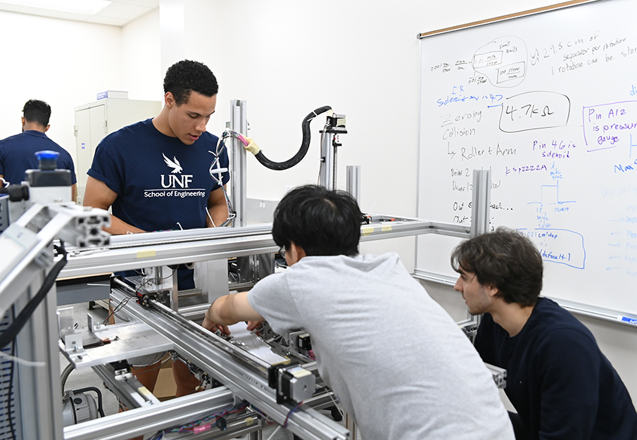 Engineering students working on a machine