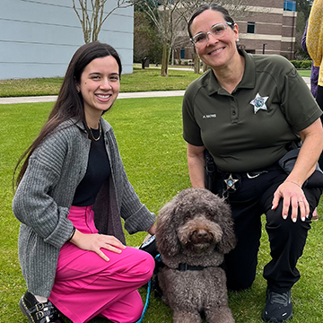 UNF student posing with an officer and her station dog