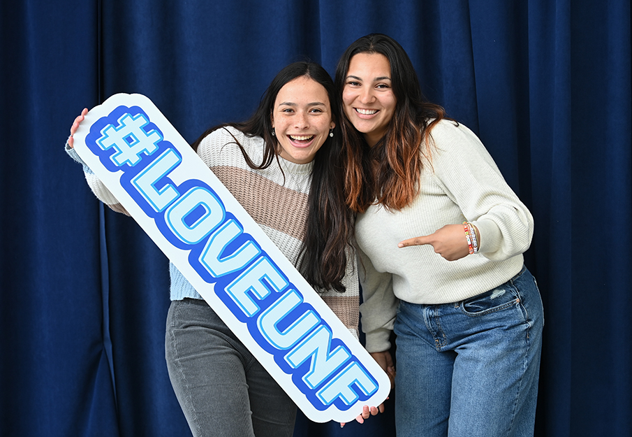 Two UNF students holding a '#LoveUNF' sign
