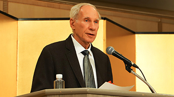 John Maraldo standing behind a podium