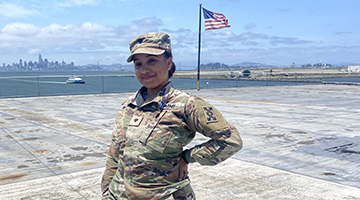 Gabriella Marquez in uniform standing on base in front of an American flag