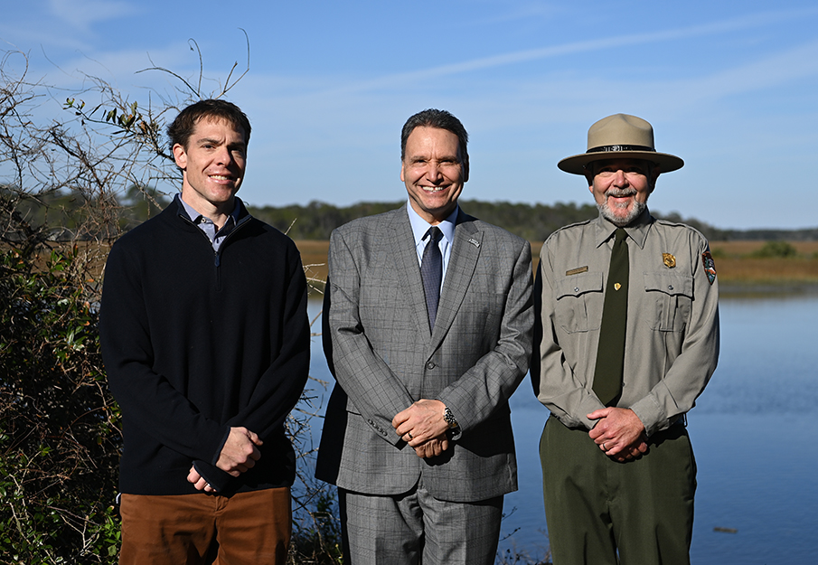 President Moez Limayem standing in front of the NPS shoreline with ranger and professor