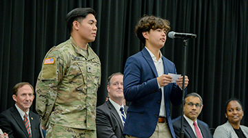 UNF student standing next to one of the new US citizens recognized at the naturalization ceremony