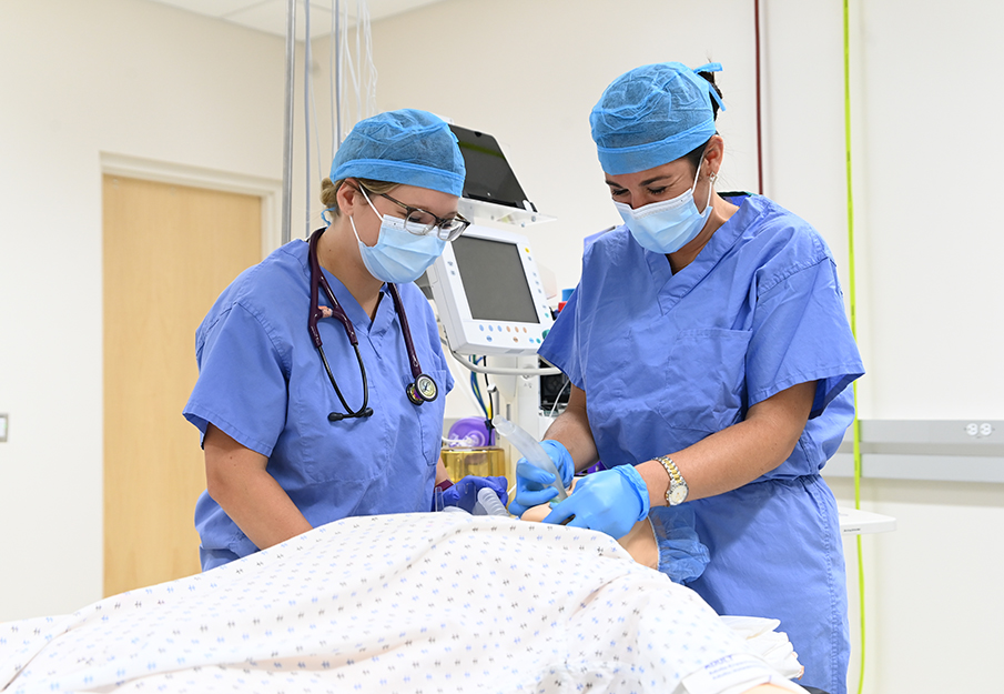 Two nursing students practicing on a dummy