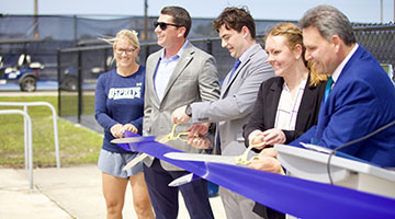 UNF President Moez Limayem and others cutting ribbon at new pickleball court