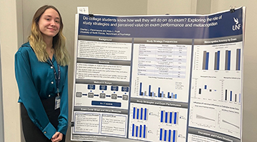 Abby Pruitt posing next to her research poster