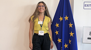 Carmen Rodriguez standing next to a European Union flag while in Brussels