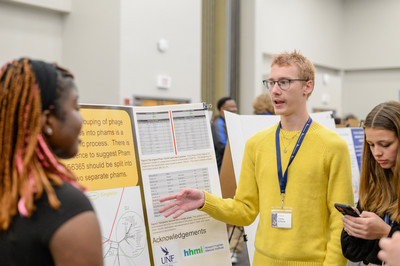 Research student speaking to attendees at the SOARS Symposium at UNF