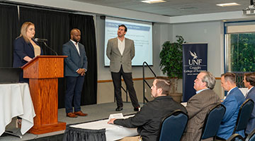 UNF students Jonathan Stephen, Shavelli Rodriguez and Richard Schultz presenting their case study solution