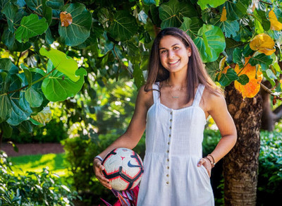 UNF student Zara Siassi posing with a soccer ball in her right hand