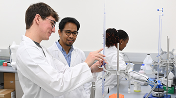 Dr. Florentino De la Cruz with students in lab
