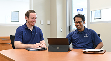 Drs. Florentino De la Cruz and Benjamin Williams sitting at a table