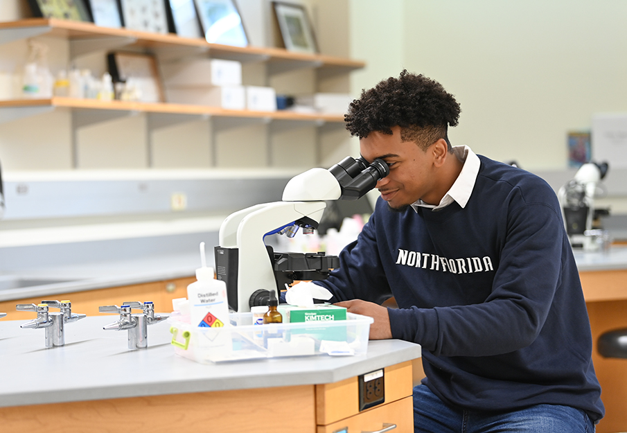 Student looking into a microscope