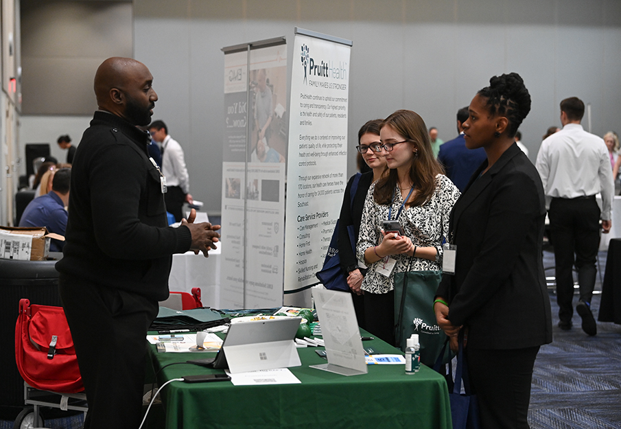 Three students talking with a recruiter from Pruitt Health at Health Career Fair 