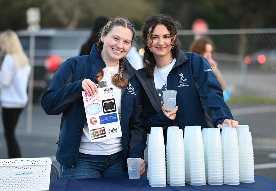 Two students working Homecoming SWAG table