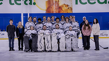 The 2025 UNF Ice Hockey team players and ice posing together on the ice of the Igloo