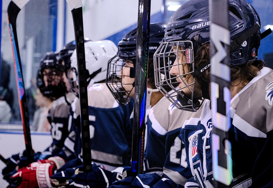 UNF Hockey players sitting on a bench waiting for game to start