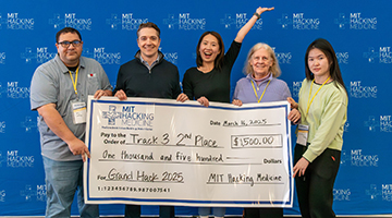 Jessica Jin standing with her hackathon team holding their winning check