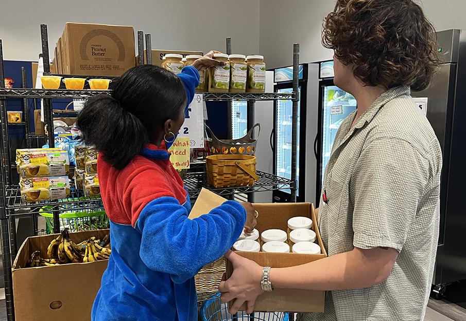 Two students stacking shelves in the Lend-A-Wing Pantry