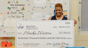 Maika Watson holding her check