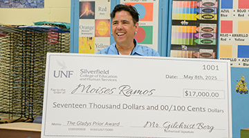 Moises Ramos holding their check