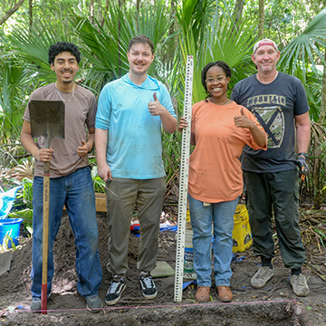 four students at the dig site