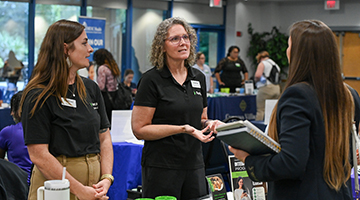 UNF student speaking to two industry partner recruiters at a Career Fair