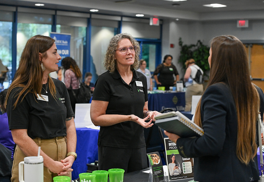 UNF student speaking to two industry partner recruiters at a Career Fair