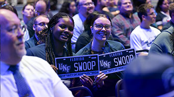 Two UNF faculty holding SWOOP license plates