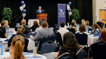 Dr. Brian Verkamp standing at podium at the employer summit