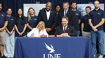 Mayor Donna Deegan signs bill for new UNF esports arena, sitting next to President Moez Limayem