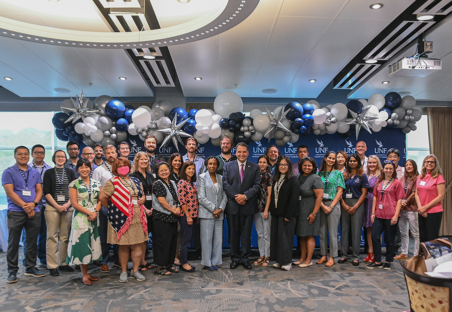 New UNF faculty posing with UNF President Moez Limayem
