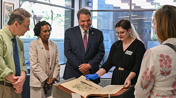 President Moez Limayem observing a book from the Lastinger Center