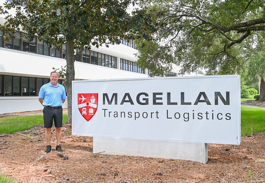 Tom Piatak standing near Magellan Transport Logistics sign in front of building