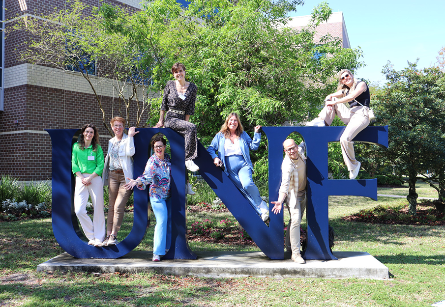 Visiting Netherlands educators posing with UNF statue