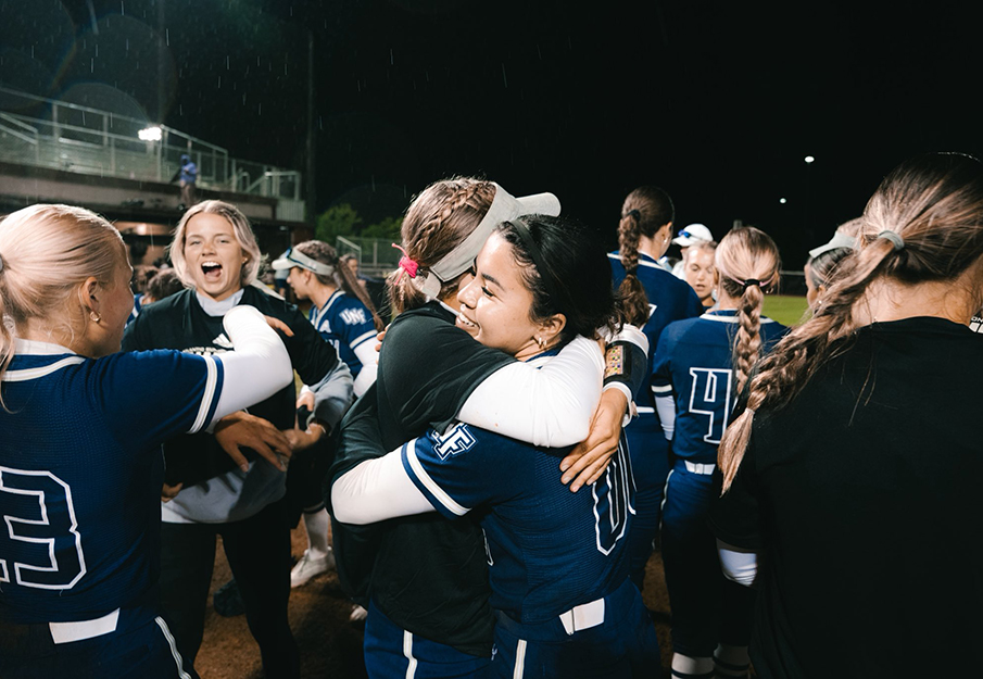 Members of the softball team hugging after winning ASUN title