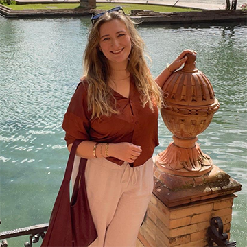 Rosemarie Baker in front of a large fountain in Spain