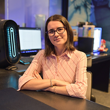 Claire Campo sitting at front desk of Esports arena