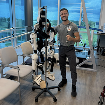 Michael Carrero standing next to robotic legs