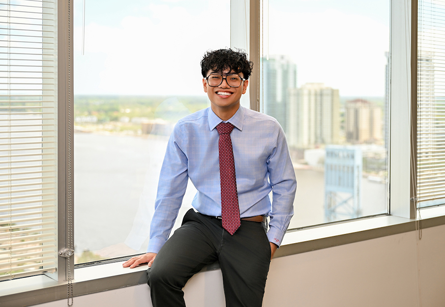 Francis Felix Javier headshot in front of city window