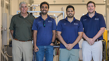 Dr. Jim Fletcher and three UNF students standing together