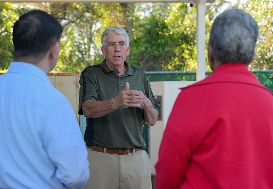 Dr. Jim Fletcher speaking to two people