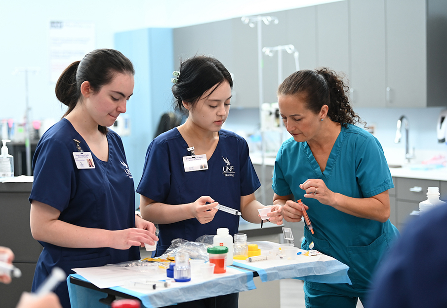 UNF nursing professor overlooking two UNF nursing students 