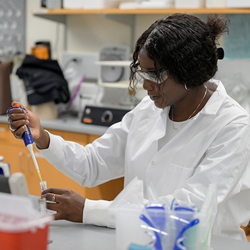 Isabella Panya in lab coat holding test tube