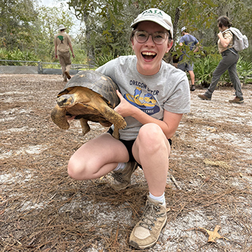 Shannon McNeil holding up a tortoise
