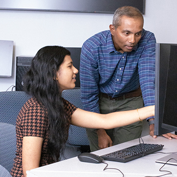 Vishwaa Shah pointing at a computer screen with Dr. Indika Kahanda standing beside her
